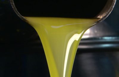 760141833-olive-oil-production-flowing-yellow-green-color